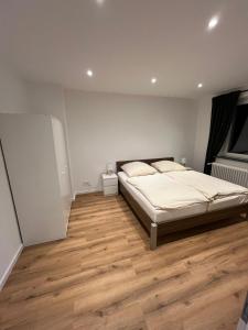 a bedroom with a bed and a wooden floor at City Apartment Schillerstraße in Wilhelmshaven
