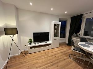 a living room with a flat screen tv on a wall at City Apartment Schillerstraße in Wilhelmshaven