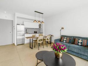a living room with a blue couch and a table at Redsearent suite with pool view 2 in Eilat