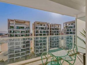 a balcony with a table and chairs and some buildings at Redsearent suite with pool view 2 in Eilat
