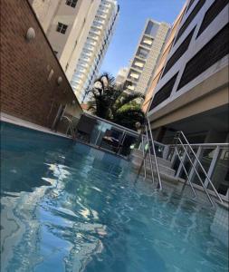 a swimming pool in front of some tall buildings at Apto em Santos - UNIQUE Residence in Santos