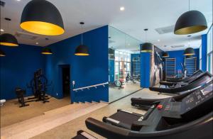 a gym with several treadmills and a blue wall at Apto em Santos - UNIQUE Residence in Santos