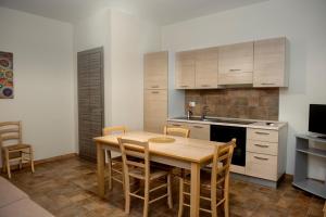 a kitchen with a wooden table and chairs in a room at Asaro Camere in Campobello di Licata +26 photos