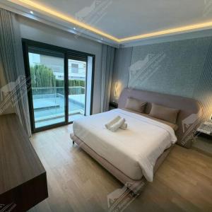 a bedroom with a large bed and a balcony at Serenity Sea Villa Taghazout Bay Amda in Taghazout