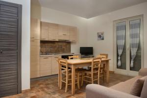 a kitchen with a table and chairs in a room at Asaro Camere in Campobello di Licata