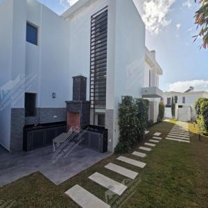 a white house with a fireplace in a yard at Serenity Sea Villa Taghazout Bay Amda in Taghazout