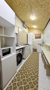 a large kitchen with white appliances and a carpet at Hostella in Salor Bekati