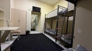 a room with three bunk beds and a desk at Hostella in Salor Bekati +2 photos