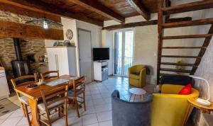 a kitchen and living room with a table and chairs at Gîte de Malavals in Castelnau-de-Mandailles