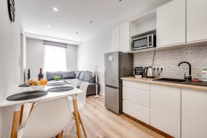 a kitchen with white cabinets and a table with fruit on it at Central Platinum Apartments 15 in Rybnik