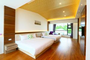 1 dormitorio con 2 camas y ventana grande en Together House, en Luodong