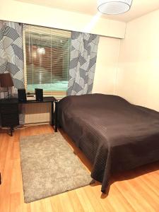 a bedroom with a large bed and a window at Luhtitalo two-room apartment in Rovaniemi +4 photos