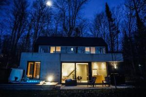 a house with a lot of windows at night at SpaHaus #128 in Lac-Superieur