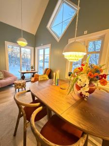 a dining room with a wooden table with flowers on it at Cabin in Tappeluft in Alta