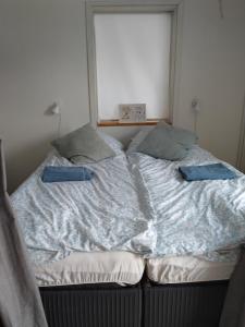 an unmade bed with two pillows on top of it at Håstrups Natur Perle in Faaborg