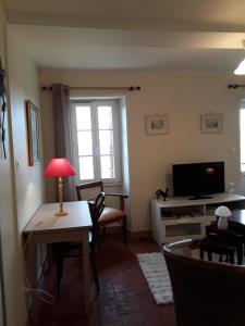 a living room with a table and a television at La Guerandelle in Ernes