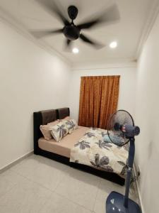 a bedroom with a bed with a ceiling fan at Puchong Permata Homestay 3BR in Puchong +4 photos