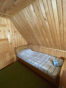 a bed in a room with a wooden ceiling at Mountain House Jelovica in Berane