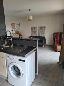 a kitchen with a washing machine in a living room at Les malices d'Ulysse in Péronne