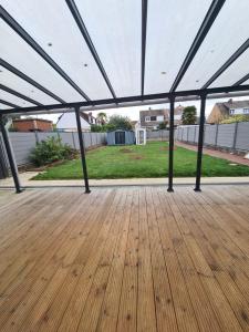 a large tent with a wooden floor in a yard at Les malices d'Ulysse in Péronne