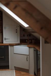 a kitchen with white cabinets and a sink at Rosa's Loft in Flamborough