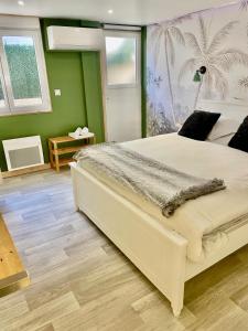 a bedroom with a large bed and a green wall at La Maison Nikaïa in Narbonne