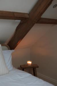 a candle sitting on a table next to a bed at Rosa's Loft in Flamborough