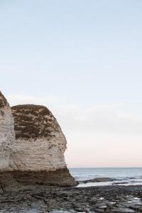 a rock on the beach next to the ocean at Rosa's Loft in Flamborough +8 photos