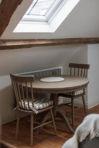 a table and chairs in a room with a skylight at Rosa's Loft in Flamborough