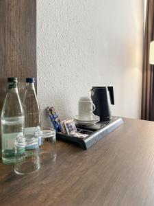 a table with two bottles and a tray with drinks at STADT-Hotel Lörrach GbR in Lörrach