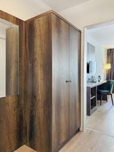 a large wooden cabinet in a room with a desk at STADT-Hotel Lörrach GbR in Lörrach
