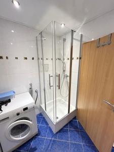 a washing machine in a bathroom with a shower at Wohnung Ahorn in Riedstadt