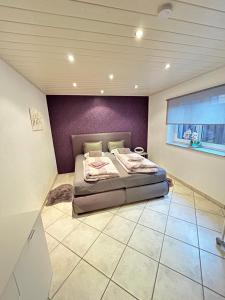 a bedroom with a bed with a purple wall at Wohnung Ahorn in Riedstadt