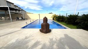 a statue sitting next to a swimming pool at Casa Del Mar, piscina privada frente al mar in Cullera