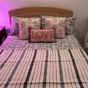 a bedroom with a bed with alove pillow on it at A beautiful stylish home in city centre in Camberley