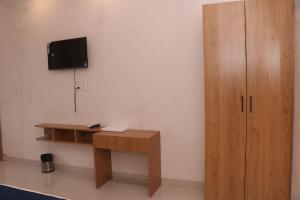 a room with a desk and a television on a wall at Hotel Lakhdatar in Kota
