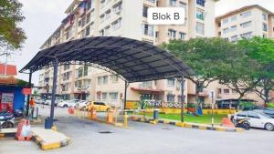 a building with a canopy in front of a parking lot at Puchong Permata Homestay 3BR in Puchong