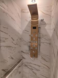 a shower in a bathroom with marble walls at studio Saphyr in Souillac +3 photos