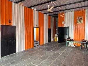an empty room with orange walls and a table at Sumai Bhakt Niwas in Tuljapur