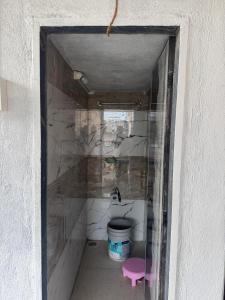 a small bathroom with a sink and a bucket at Sumai Bhakt Niwas in Tuljapur