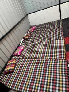a bed with pillows on it in a room at Sumai Bhakt Niwas in Tuljapur