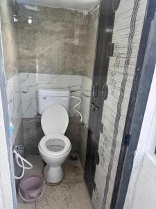 a small bathroom with a toilet in a stall at Sumai Bhakt Niwas in Tuljapur +1 photo