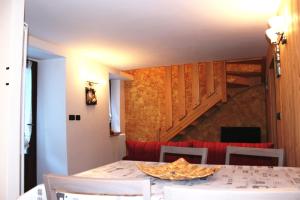 a dining room with a table and chairs and a staircase at Maison Leveque in Brusson