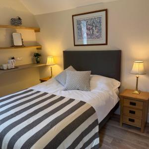 a bedroom with a bed and two lamps and shelves at Town Centre - 22 Billet Street in Taunton