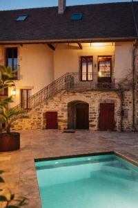 a house with a swimming pool in front of a house at Sur Les Roches in Dracy-lès-Couches