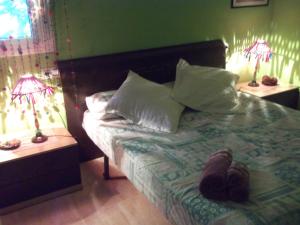 Una cama con dos lámparas y un par de zapatos. en Apartamento Gerard, en Riumar