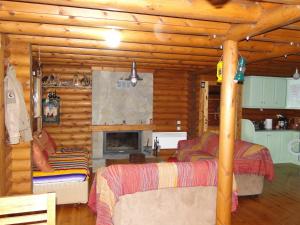 Dormitorio en cabaña de madera con 2 camas y chimenea en Katafygio Chalet, Krikello, en Kríkellon