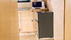 a kitchen with a refrigerator and a microwave on a counter at Agape hostel in Bagamoyo