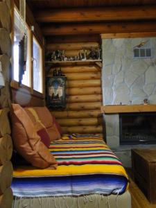 a bed in a log cabin with a fireplace at Katafygio Chalet, Krikello in Kríkellon