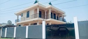 a house with a balcony on top of a fence at Agape hostel in Bagamoyo